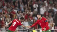 Bintang Portugal Cristiano Ronaldo (kanan) saat mencetak gol ke gawang Skotlandia pada ajang UEFA Nations League 2024/2025. Tampak ia bersalaman dengan rekan setimnya Bruno Fernandes. (Patricia DE MELO MOREIRA / AFP)