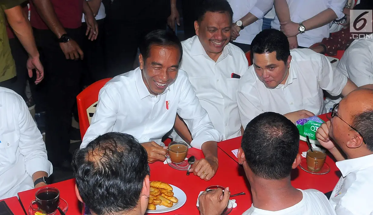 Capres nomor urut 01 Joko Widodo atau Jokowi, Gubernur Sulut Olly Dondokambey dan Ketua TKN Erick Thohir saat ngopi di Jalan Roda, Manado, Minggu (31/3). Selain menikmati kopi, Jokowi juga disajikan pisang goreng sambil mendengar aspirasi dari masyarakat. (Liputan6.com/Angga Yuniar)