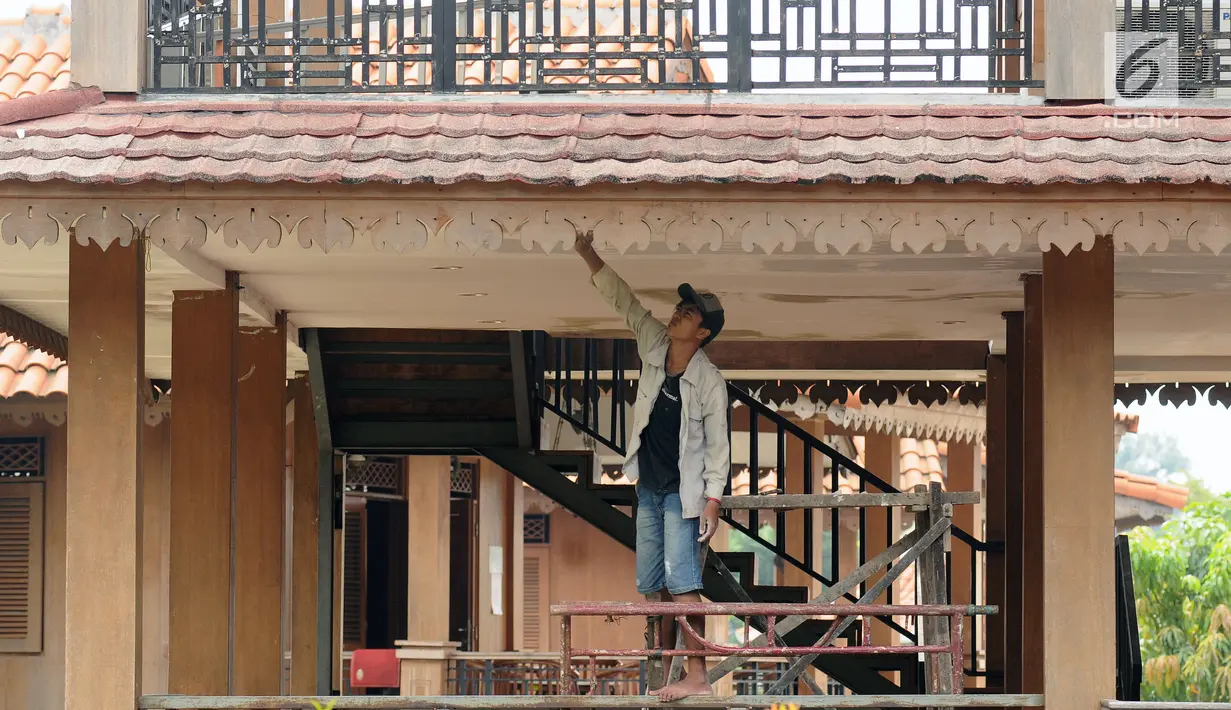 Pekerja melakukan perbaikan salah satu ruang pertemuan di Setu Babakan, Jakarta, Jumat (14/7). Setu Babakan akan menjadi lokasi pelaksanaan Lebaran Betawi 2017 yang akan digelar pada 21 - 23 Juli 2017. (Liputan6.com/Helmi Fithriansyah)
