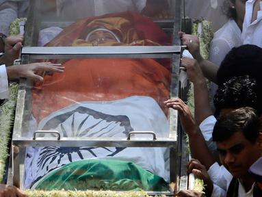 Jenazah aktris Bollywood Sridevi Kapoor dibaringkan dalam peti kaca dan berbalut bendera India saat akan dikremasi di Mumbai, India, Rabu (28/2). Ribuan penggemar berkabung dan memberi penghormatan terakhir untuk Sridevi. (AP Photo/Rajanish Kakade)