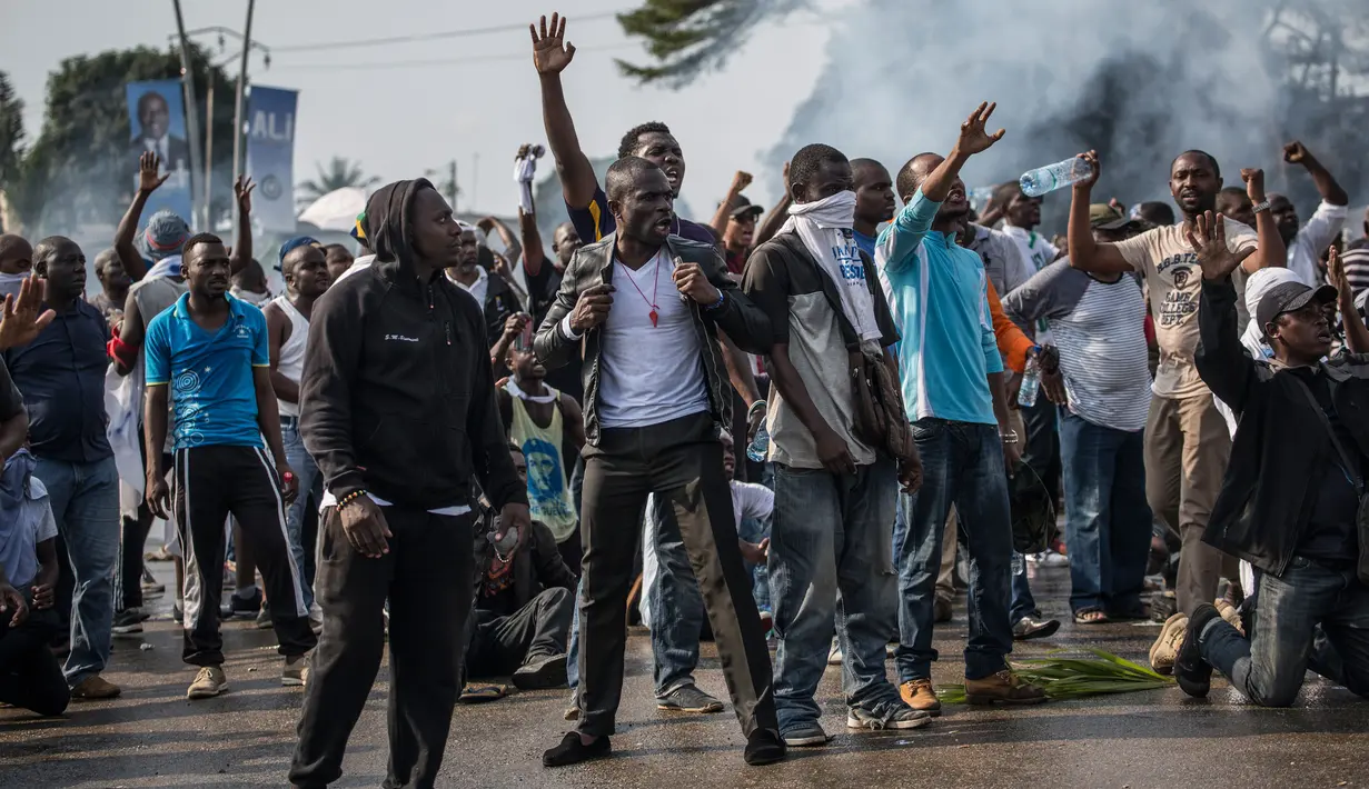 Pendukung kandidat oposisi Gabon, Jean Ping, yang berdemonstrasi dihalangi pasukan keamanan saat mencoba masuk markas komisi pemilihan di Libreville, Rabu (31/8). Demonstrasi meletus setelah Presiden Gabon, Ali Bongo terpilih kembali. (MARCO LONGARI/AFP)