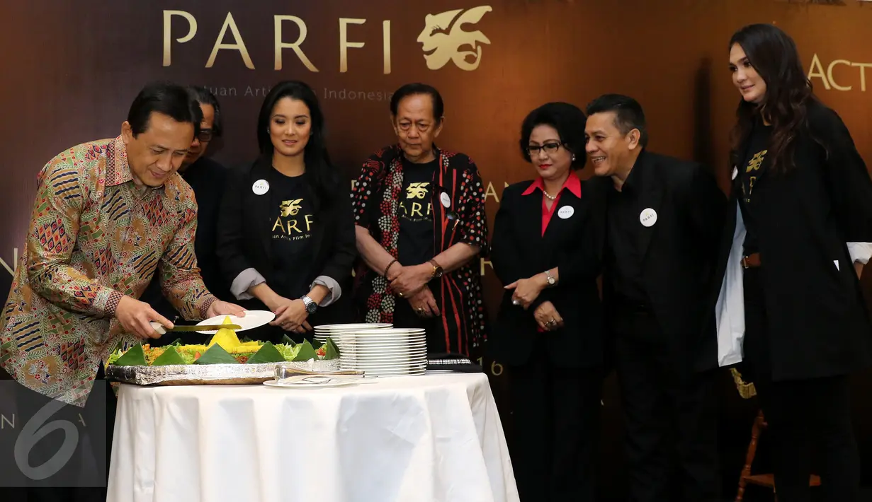 Ketua Badan Ekonomi Kreatif, Triawan Munaf memotong tumpeng bersama pengurus besar PARFI 56 Jakarta, Senin (24/10). Kepengurusan periode 2016- 2021 terdiri dari 30 anggota baru. (Liputan6.com/Herman Zakharia)