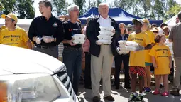 Presiden AS, Donald Trump membawa makanan sebelum dibagikan kepada korban badai Florence di Temple Baptist Church di New Bern, N.C. (19/9). Badai tersebut juga membuat hampir seluruh kota di North Carolina dibanjiri lumpur dan air. (AP Photo /Evan Vucci)