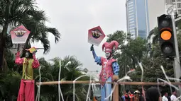 Badut menyosialisasikan sistem tilang Electronic Traffic Law Enforcement (ETLE) kepada pengunjung car free day (CFD) di Bundaran HI, Jakarta, Minggu (25/11). Sistem tilang ETLE menggunakan CCTV berteknologi canggih. (Merdeka.com/Iqbal Nugroho)