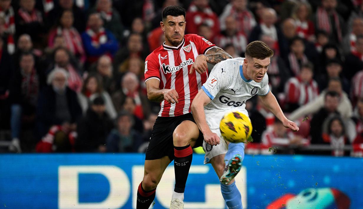 Pemain Girona, Viktor Tsygankov (kanan) berebut bola dengan pemain Athletic Bilbao, Yuri Berchiche pada laga lanjutan Liga Spanyol 2023/2024 di San Mames Stadium, Bilbao, Spanyol, Selasa (20/02/2024) dini hari WIB. (AFP/Ander Gillenea)