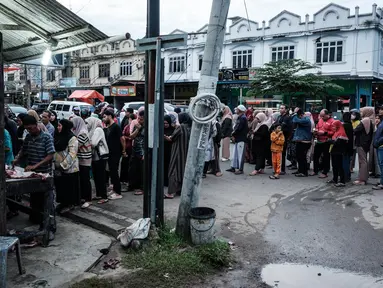 Orang-orang mengantre untuk membeli daging di salah satu toko daging di Banda Aceh, pada 27 Februari 2025. (YASUYOSHI CHIBA/AFP)