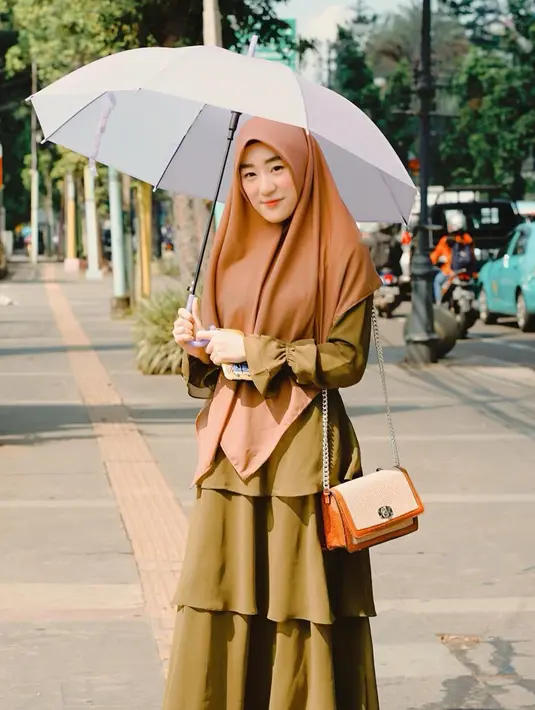 Larissa memang memilih menggunakan hijab syar'i sebagai penutup auratnya. Meski begitu, penampilan Larissa dengan hijab syar;i tetap trendi dengan hijab coklat gamis bewarna hijau dan tas yang senada dengan hijab. (Liputan6.com/IG/larissachou)