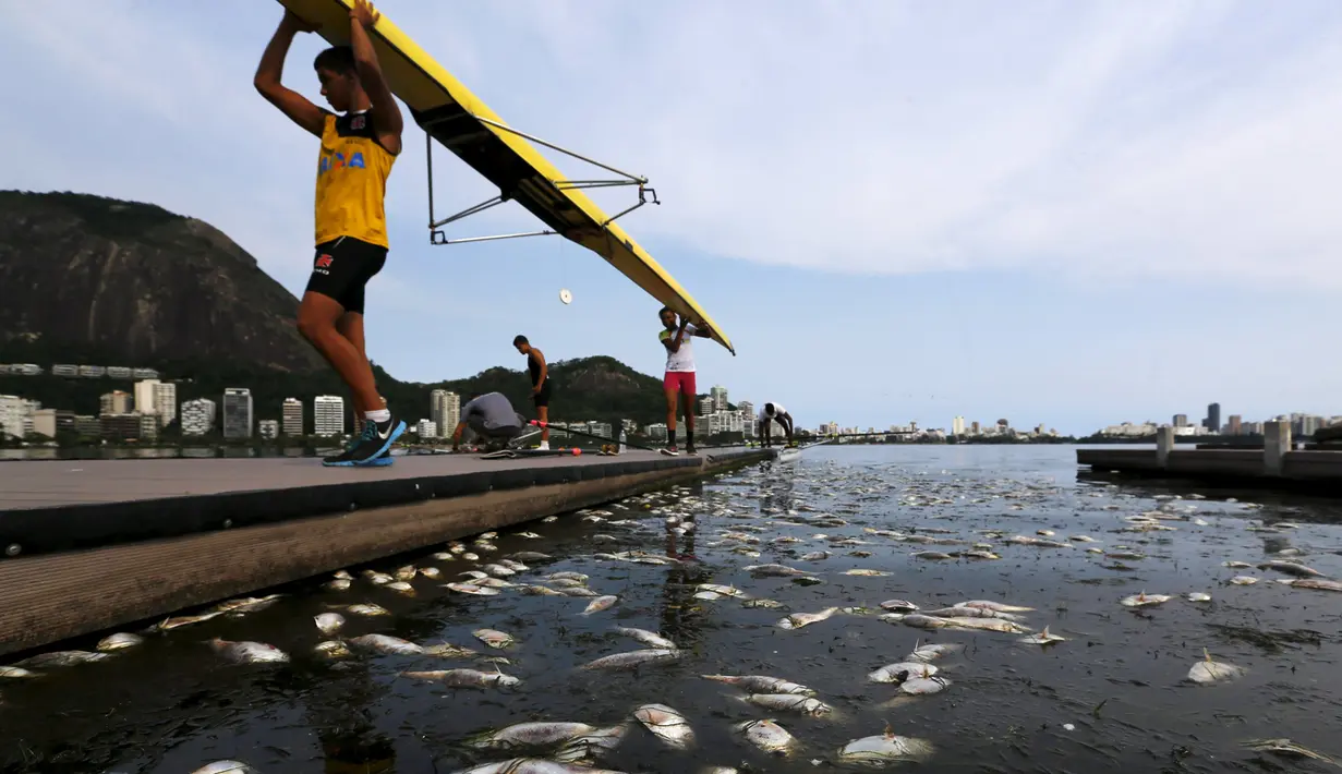 Atlet dayung usai melakukan latihan diantara ribuan ikan mati di arena latihan atlet dayung Laguna Rodrigo de Freitas, Rio de Janeiro, Brasil, Senin (13/4/2015). Ikan-ikan ini  mati akibat air laut dingin yang masuk ke Laguna. (REUTERS/Ricardo Moraes)
