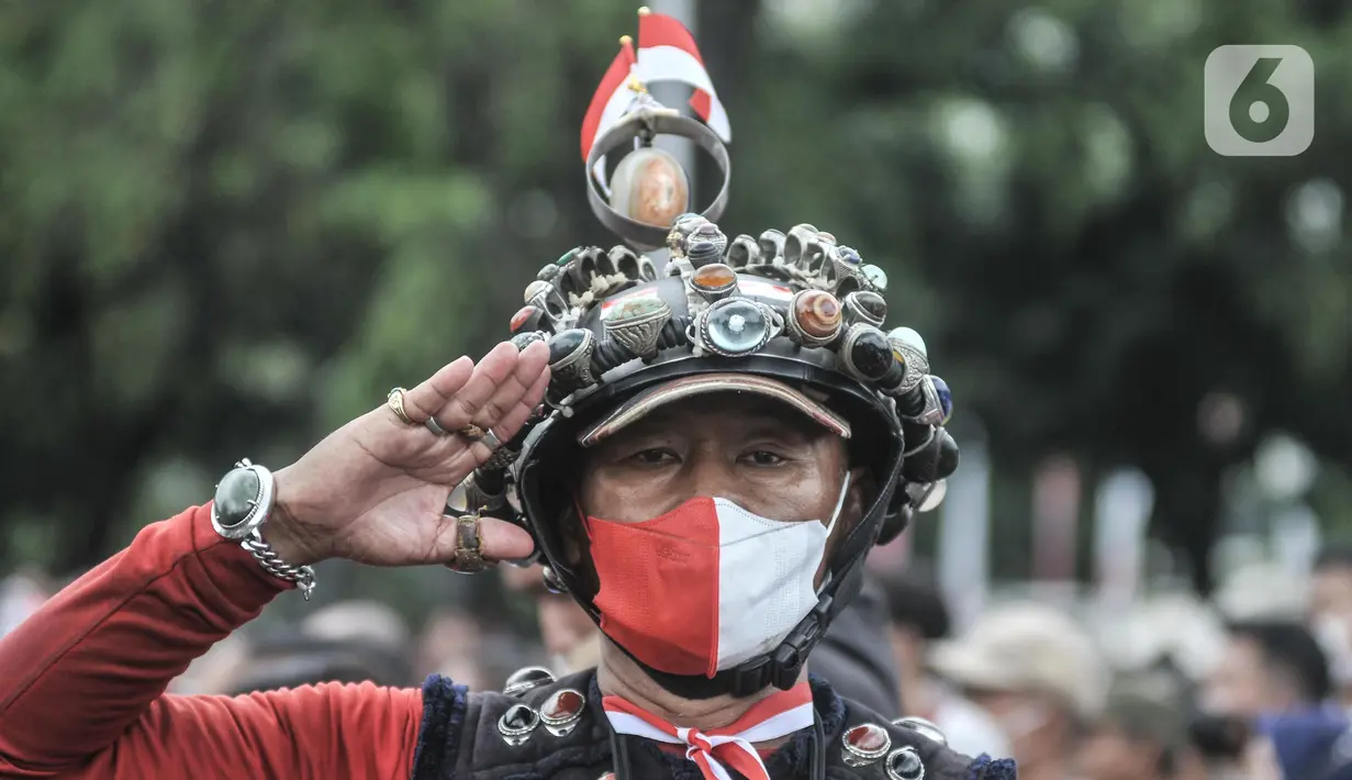 Warga memberikan hormat saat pengibaran bendera Merah Putih dalam Upacara HUT ke-77 Republik Indonesia yang disaksikan dari Taman Aspirasi Monumen Nasional (Monas), Rabu (17/8/2022). Setelah sempat ditiadakan selama 2 tahun akibat pandemi Covid-19, Upacara Peringatan Kemerdekaan Republik Indonesia disambut antusias warga dari berbagai daerah yang berdatangan untuk mengikuti meski hanya dari luar Istana Negara. (merdeka.com/Iqbal S Nugroho)