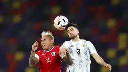 Pemain Argentina, Nicolas Tagliafico, duel udara dengan pemain Chili, Eduardo Vargas, pada Kualifikasi Piala Dunia 2022 Zona Amerika Selatan di Stadion Santiago del Estero, Jumat (4/6/2021). Kedua tim bermain imbang 1-1. (Agustin Marcarian, Pool via AP)