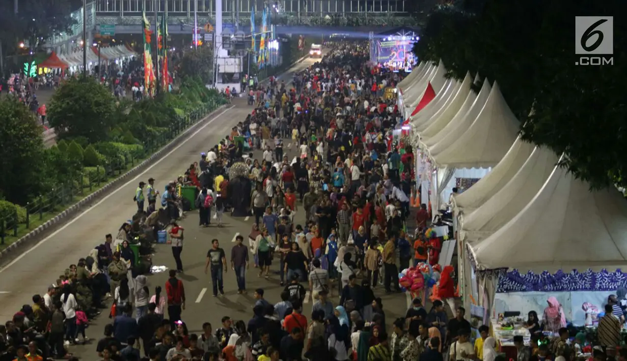 Warga memadati malam pergantian tahun di Jalan MH Thamrin, Jakarta, Minggu (31/12). Pemprov DKI Jakarta memberlakukan car free night di Jalan Sudirman hingga Thamrin. (Liputan6.com/Angga Yuniar)