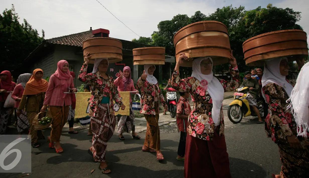 Sejumlah warga membawa Tenongan pada ritual Nyadran di dusun Kledokan, Selomartani, Sleman, Kamis (2/6). Nyadran merupakan ritual berziarah dan mengirim doa ke makam leluhur menjelang bulan Ramadan. (Liputan6.com/Boy Harjanto)