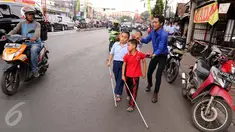 Guru membimbing siswa PSBN Cahaya Bathin penyandang tunanetra mengikuti praktik orientasi mobilitas di Cawang, Jakarta, Selasa (11/4). Praktik itu untuk melatih kemandirian siswa menghadapi situasi apapun dalam kesehariannya. (Liputan6.com/Gempur M Surya)