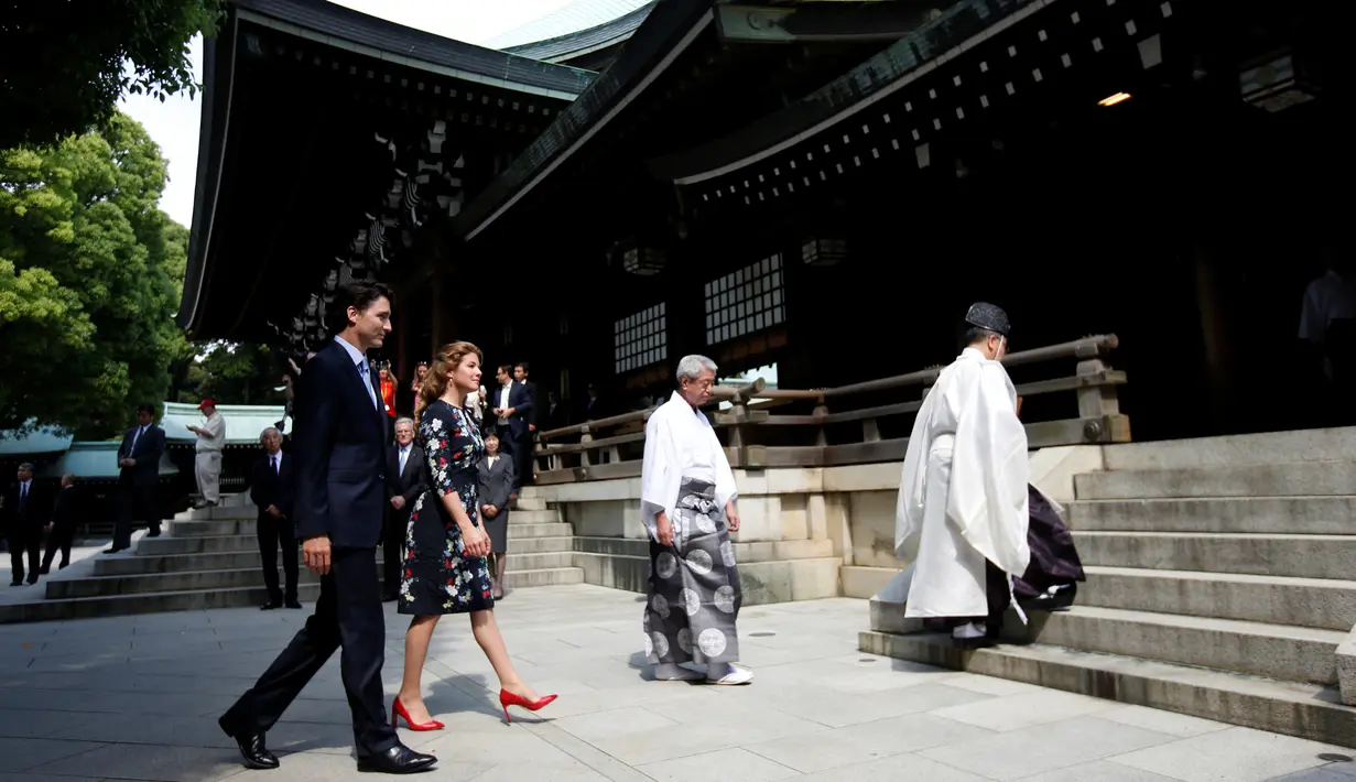 PM Kanada Justin Trudeau  dan istri berjalan dipimpin oleh Shinto Imam As saat mengunjungi Kuil Meiji di Tokyo, Jepang (24/5). Kedatangan Justin Trudeau untuk melakukan pertemuan KTT G7 Ise-Shima. (REUTERS /Issei Kato)