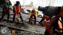 Pekerja menyelesaikan proses penggantian bantalan rel kereta api di kawasan Stasiun Karet, Jakarta, Rabu (28/12). Perawatan tersebut dilakukan untuk memperbaiki keseimbangan tinggi dan rendah rel kereta. (Liputan6.com/Gempur M. Surya)