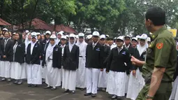 Ratusan siswa SMKN 27 Jakarta saat berkumpul di lapangan untuk mendengarkan pengarahan dari Gubernur DKI Basuki Tjahaja Purnama, Senin (13/4/2015). 293 murid SMKN 27 Jakarta hari ini mengikuti UN hari pertama. (Liputan6.com/Herman Zakharia)