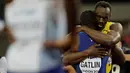 Pelari AS, Justin Gatlin memeluk Usain Bolt setelah menjadi juara pada lomba lari 100 meter Kejuaraan Dunia Atletik 2017 di Stadion London, Minggu (6/8). Usai kemenangannya, Gatlin meminta maaf dan berlutut di hadapan Bolt. (AP/Matthias Schrader)