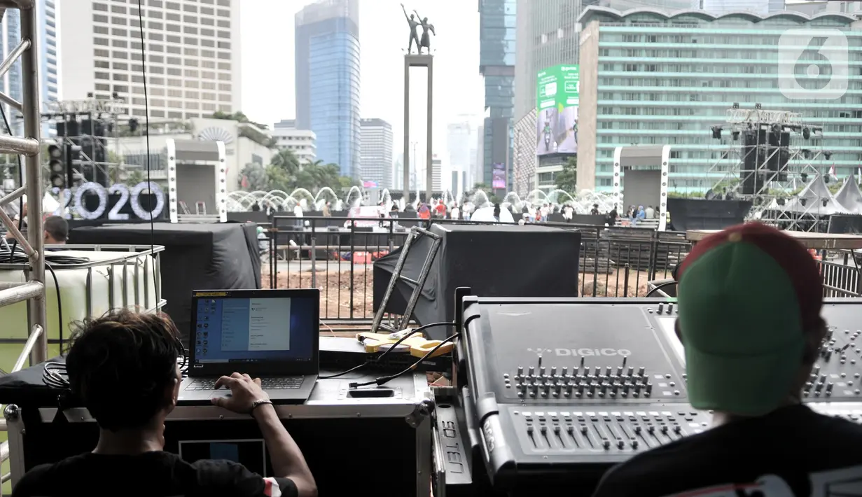 Pekerja saat menyelesaikan persiapan panggung hiburan untuk malam penyambutan Tahun Baru di Bundaran HI, Jakarta, Selasa (31/12/2019). Panggung megah disiapkan untuk memeriahkan Car Free Night dan pergantian tahun baru 2020 dengan menghadirkan sejumlah artis papan atas. (merdeka.com/Iqbal Nugroho)