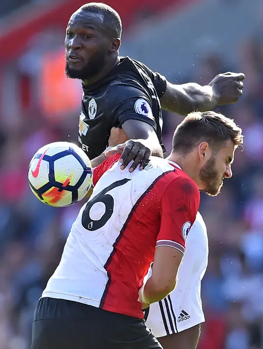 Striker Manchester United, Romelu Lukaku, duel udara dengan bek Southampton, Wesley Hoedt, pada laga Premier League di Stadion St Mary's, Sabtu (23/9/2017). Manchester United menang 1-0 atas Southampton. (AFP/Glyn Kirk)