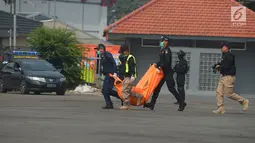 Petugas membawa kantong jenazah dalam simulasi penanganan teror di JI Expo Kemayoran, Jakarta, Rabu (25/7). Simulasi yang diikuti itu personel TNI, Polri dan instasi terkait tersebut sebagai upaya pengamanan Asian Games 2018. (Merdeka.com/Imam Buhori)