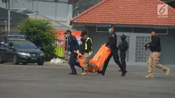 Petugas membawa kantong jenazah dalam simulasi penanganan teror di JI Expo Kemayoran, Jakarta, Rabu (25/7). Simulasi yang diikuti itu personel TNI, Polri dan instasi terkait tersebut sebagai upaya pengamanan Asian Games 2018. (Merdeka.com/Imam Buhori)