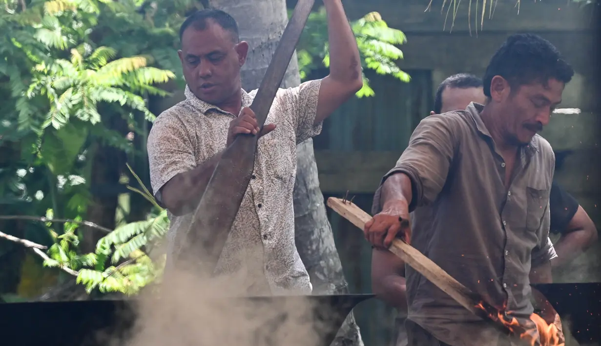 Memasak kari ini menggunakan wajan yang besar dengan api dari kayu bakar. (Chaideer Mahyuddin/AFP)