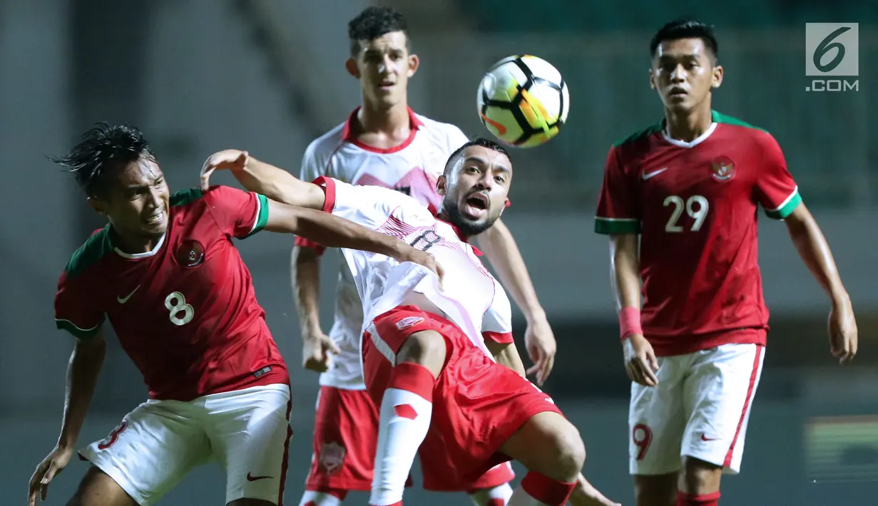 Pemain tengah Indonesia U-23, M Hargianto (kiri) berebut bola dengan penyerang Bahrain, Mohamed Marhoon pada laga PSSI Anniversary 2018 di Stadion Pakansari, Kab Bogor, Jumat (27/4). Indonesia kalah 0-1. (Liputan6.com/Helmi Fithriansyah)