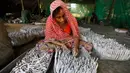 Pekerja mengisi tabung dengan gulungan kertas berisi bubuk mesiu untuk petasan, di sebuah pabrik pinggiran Ahmadabad, Senin (22/10). Permintaan petasan di India semakin meningkat jelang perayaan Festival "Cahaya" Diwali bagi umat Hindu. (AP/Ajit Solanki)