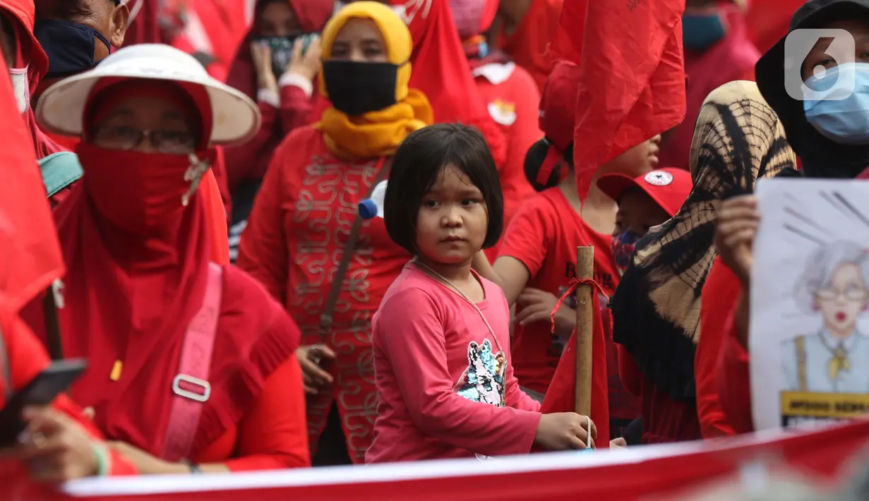Seorang anak terlihat dalam aksi unjuk rasa menolak pengesahan UU Omnibus Law Cipta Kerja di Kawasan Patung Kuda, Jakarta, Jumat (16/10/2020). Meski sudah ada imbauan untuk tidak membawa anak-anak dalam aksi unjuk rasa namun sejumlah orang tua tetap menyertakan. (Liputan6.com/Helmi Fithriansyah)