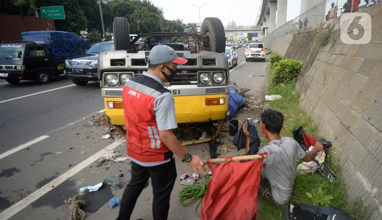Truk bermuatan puing terbalik akibat salah satu ban belakang lepas di jalan tol Pondok Indah dekat pintu keluar Lebak Bulus, Jakarta, Jumat (29/5/2020). Dalam kecelakaan tersebut tidak ada korban jiwa namun membuat kendaraan yang melintas jalan tol tersendat. (merdeka.com/Dwi Narwoko)
