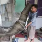 Pengerajin berbahan dasar kulit ular tengah memproduksi tas di bengkel kerja di Cibitung, Jawa Barat, Selasa (12/4). Dalam sebulan dapat memproduksi 200 buah dengan harga jual 50 ribu-8 juta. (Liputan6.com/Angga Yuniar)