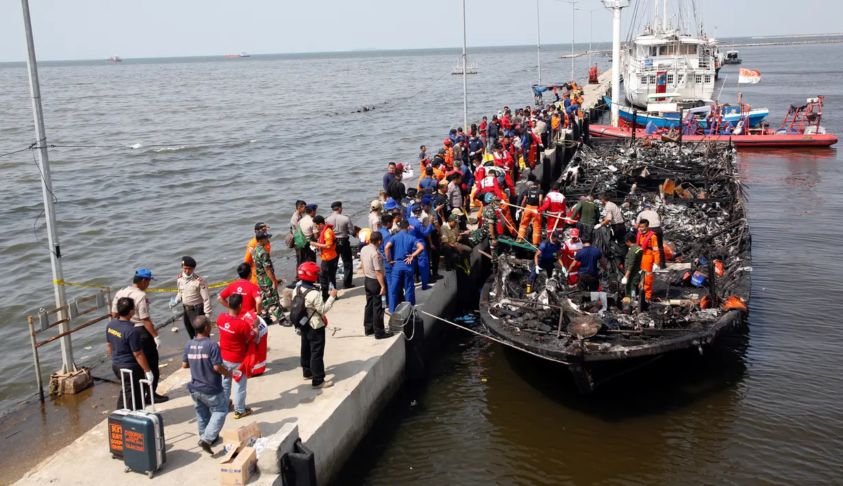 Kapal Zahro Express yang terbakar di perairan Kepulauan Seribu, tiba di Pelabuhan Muara Angke, Jakarta, Minggu (1/1). Dilaporkan sebanyak 23 orang meninggal dunia, 17 luka-luka, 17 orang hilang dan 194 orang selamat. (REUTERS/Darren Whiteside)
