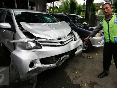 Petugas menunjukan mobil yang ringsek akibat kecelakaan lalulintas di simpang empat Tugu Pal Putih Yogyakarta, Senin (30/5). Kecelakaan yang terjadi pada minggu (29/5) pagi ini menewaskan 2 orang. (Boy Harjanto)
