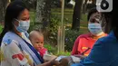 Mahasiswa memberikan makanan gratis kepada masyarakat di UKI, Cawang, Jakarta, Selasa (16/3/2021). Kegiatan ini memberikan 500 bungkus nasi, masker dan vitamin setiap harinya sejak pukul 06.00 WIB, untuk meringankan beban masyarakat di masa pandemi Covid-19. (Liputan6.com/Herman Zakharia)