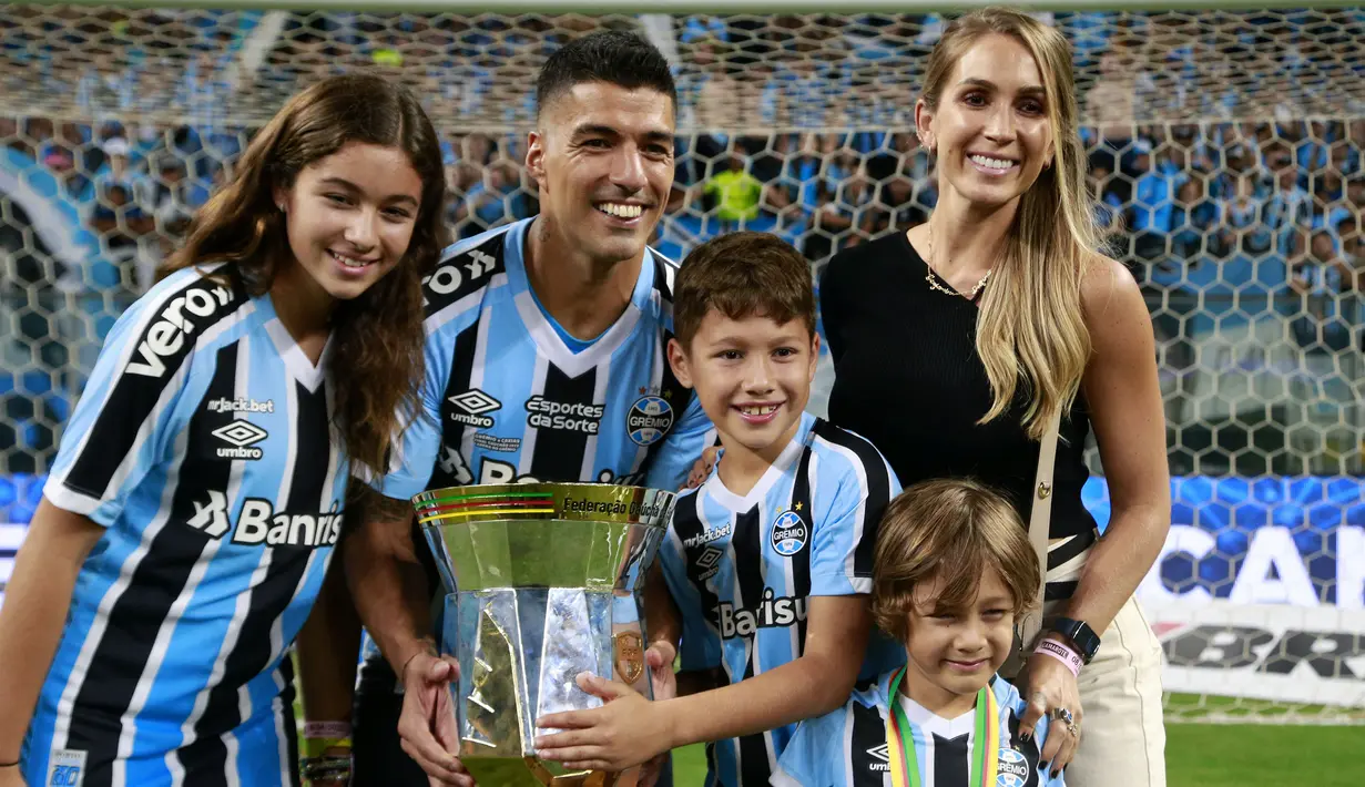 Pemain Gremio, Luis Suarez berpose dengan keluarganya setelah memenangkan Gaucho Championship di Arena do Gremio Stadium, Porto Alegre, Brasil, 8 April 2023. (AFP/Silvio Avila)