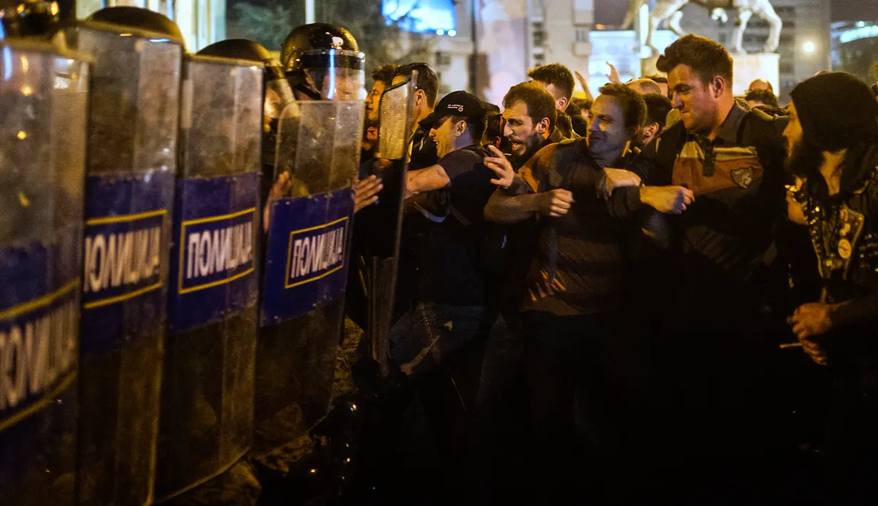Demonstran bentrok dengan polisi anti huru hara saat aksi menuntut pengunduran diri Presiden Gjorge Ivanov di Skopje, Makedonia, Rabu (13/4). Mereka memprotes keputusan Presiden memberikan pengampunan bagi 56 politikus (Robert ATANASOVSKI/AFP)