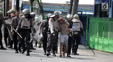 Polisi menangkap seorang pria saat tarjadi bentrok dengan massa di kawasan Petamburan, Jakarta Barat, Rabu (22/5/2019). Kapolres Metro Jakarta Barat Kombes Hengki Haryadi mengatakan ada 99 orang diamankan di Polres Jakarta Barat dan Polda Metro Jaya. (Liputan6.com/Faizal Fanani)