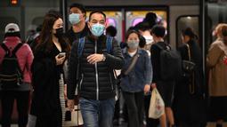 Orang-orang memakai masker di sistem Mass Transit Railway (MTR) di Hong Kong pada 27 Februari 2023. Langkah perpanjangan mandat masker dilakukan di tengah upaya pemerintah untuk menarik wisatawan dan pekerja asing untuk membantu menghidupkan kembali ekonomi negara itu yang terpuruk. (AFP/Peter Parks)