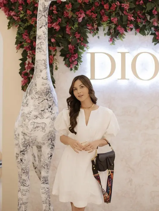 Jessica Mila tampil simple mengenakan mini dress putih namun tetap terlihat mewah dengan tas Dior dan kalung emasnya. @jscmila
