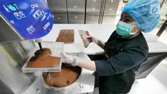Pekerja memasukkan cokelat cair ke dalam alat cetak di toko Pipiltin Cocoa kawasan Barito, Jakarta, Kamis (13/9). Pipiltin Cocoa cukup banyak diburu oleh para atlet Asian Games 2018. (Liputan6.com/Herman Zakharia)