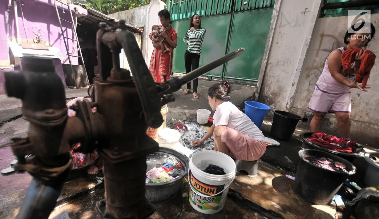 Warga mencuci pakaian di pinggir jalan kawasan Kramat Pulo, Senen, Jakarta, Kamis (27/12). Meski hanya menggunakan pompai air manual, warga Kramat Pulo mengaku nyaman mencuci di pinggir jalan karena gratis. (Merdeka.com/Iqbal S. Nugroho)