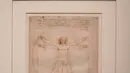 Awak media mengambil gambar "Vitruvian Man" karya Leonardo Da Vinci di museum Louvre, Paris, Selasa (22/10/2019). Louvre Paris, rumah Mona Lisa, menggelar pameran terbesar  Leonardo da Vinci memperingati 500 tahun wafatnya maestro Italia itu yang dibuka 24 Oktober mendatang (AP/Thibault Camus)