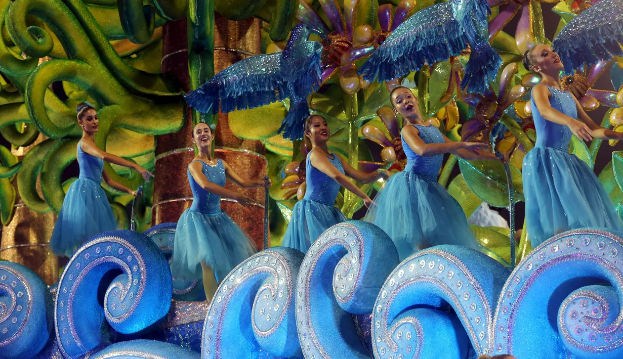 Peserta dari sekolah samba Perola Negra menari diatas mobil yang dihias secara unik untuk memeriahkan Karnaval Tahunan Brasil di Sao Paulo (5/2). (REUTERS/Paulo Whitaker)