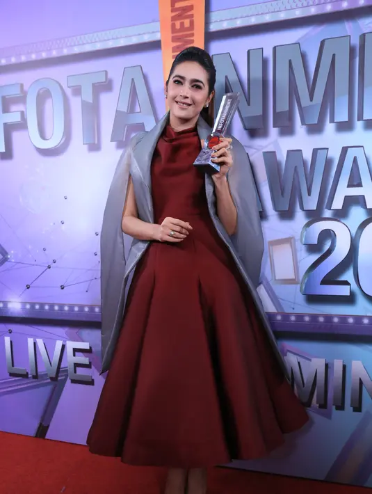Hadir di panggung Infotainment Awards 2017, Nabila mengenakan longdress berwarna merah maroon dipadu dengan cape abu-abunya. Dengan tatanan rambut dan riasan wajahnya Nabila memang sangat memikat. (Adrian Putra/Bintang.com)