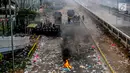 Polisi membuat barikade saat menghalau mahasiswa dalam demonstrasi menolak pengesahan RUU KUHP dan revisi UU KPK di depan Gedung DPR, Jakarta, Selasa (24/9/2019). Dua polisi dan tiga mahasiswa dilaporkan terluka dalam demonstrasi tersebut. (Liputan6.com/Faizal Fanani)