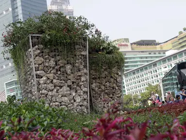 Salah satu warga memotret Instalasi Gabion saat CFD di kawasan Bundaran Hotel Indonesia, Jakarta, Minggu (25/8/2019). Pengadaan Instalasi Gabion ini menggunakan Anggaran Pendapatan dan Belanja Daerah (APBD) Dinas Kehutanan DKI sebesar Rp 150 juta. (Liputan6.com/Helmi Fithriansyah)