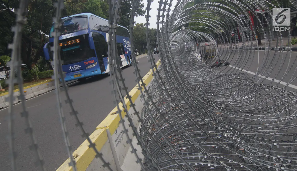 Kawat berduri terpasang di sebagian ruas Jalan Medan Merdeka Barat depan Gedung Mahkamah Konstitusi, Jakarta, Kamis (13/6/2019). Sekitar 12.000 pesonel gabungan akan menjaga sidang Perselisihan Hasil Pemilihan Presiden/Wakil Presiden Pemilu 2019. (Liputan6.com/Helmi Fithriansyah)