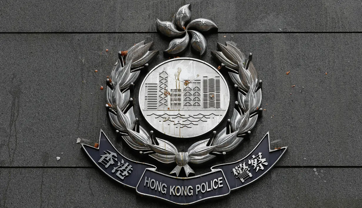 Telur yang dilontarkan oleh para demonstran mengotori lencana polisi di markas kepolisian di Hong Kong, Sabtu (22/6/2019). Markas Besar Polisi Hong Kong tersebut digeruduk ribuan demonstran yang menuntut polisi membebaskan massa yang ditangkap dalam aksi menolak RUU Ekstradisi. (AP Photo/Vincent Yu)