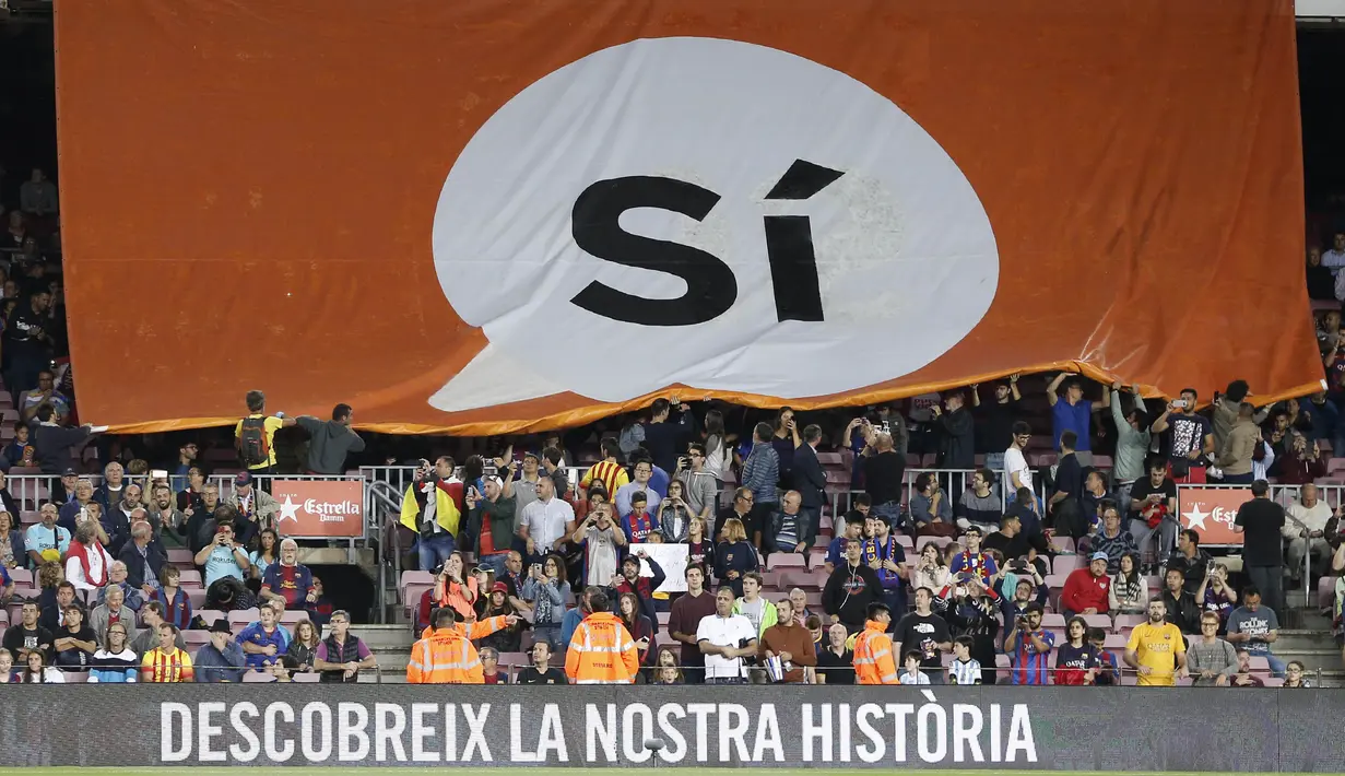 Suporter Barcelona membentangkan bendera referendum Catalan dengan tulisan "Yes"saat laga La Liga Spanyol di Camp Nou stadium, Barcelona (19/9/2017). Barcelona menang 6-1. (AFP/Pau Barrena)