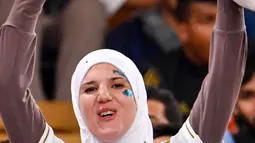 Seorang fans perempuan mengenakan jersey Real Madrid bersorak sebelum pertandingan melawan Valencia pada semifinal Piala Super Spanyol King Abdullah Sport City di kota pelabuhan Arab Saudi, Jeddah (8/1/2020). (AFP Photo/Guiseppe Cacace)